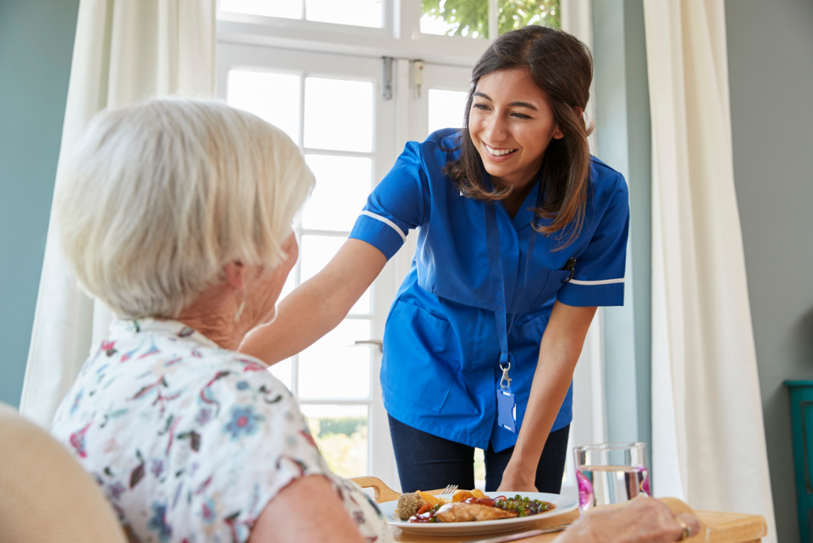 Nurse assisting elderly lady at home